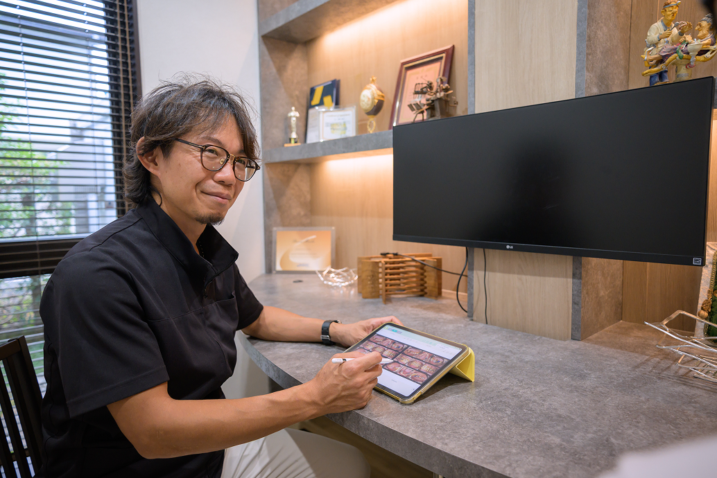 カウンセリングで資料を確認する歯科医師